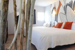 Bielle罗杰斯拉格拉德酒店的卧室配有带橙色枕头的白色床