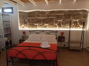 阿尔盖罗Ninfa Alghero的一间卧室设有一张床和石墙