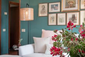 卡斯蒂里昂纳·德拉佩Belvedere apartment的客厅拥有蓝色的墙壁和白色的沙发,鲜花盛开。
