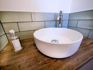圣梅尔林Padstow Escapes - Breakers Holiday Cottage的浴室内木制柜台上的白色水槽