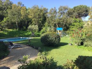 卡隆赫Belvilla by OYO Vall Repos的一个带游泳池和树木的花园