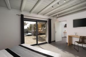 米克诺斯城Ikies of Mykonos的一间卧室设有一张床和一个滑动玻璃门