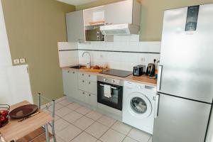普瓦捷Apparthotel - Horizon Poitevin的厨房配有冰箱和洗衣机。