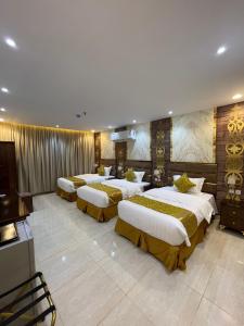 Al ḨanākīyahAl Wissam Golden Hotel的酒店客房的四张床位