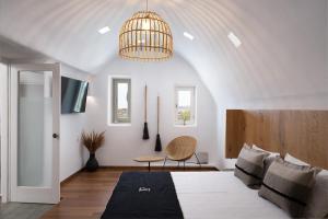 米克诺斯城Ikies of Mykonos的一间卧室配有一张大床和一个吊灯。