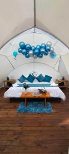 莱瓦镇Origen Glamping en Villa de Leyva的一间设有一张床铺的帐篷,配有蓝色气球