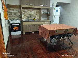 梅塞德斯La Baquiana的厨房配有桌子、炉灶和冰箱。