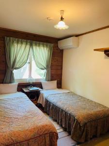 高森町山林舍的酒店客房设有两张床和窗户。