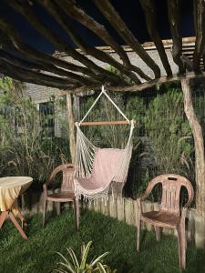 巴纳内拉斯Tiny Home Garden Bananeiras的花园内的吊床,配有两把椅子和一张桌子