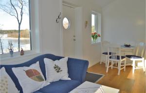 格里斯勒港Awesome Home In Grisslehamn With Kitchen的客厅设有蓝色的沙发和窗户。