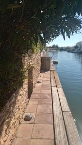 艾姆布里亚布拉瓦Villa Empuriabrava on main canal with 13 m private mooring, private pool, air con in all rooms, non-smoking的水体旁的路径