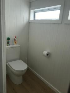 泰鲁阿Serendipity Wharf Cottage的白色的浴室设有卫生间和窗户。