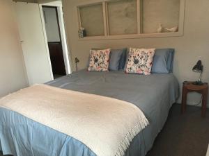 泰鲁阿Serendipity Wharf Cottage的一间卧室配有一张大床和两个枕头