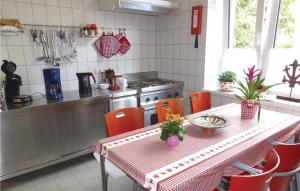 奥尔巴赫Nice Home In Auerbach With Wifi的厨房配有带橙色椅子的桌子和炉灶。