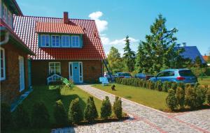 伯尔格伦德-雷特维施Haus Nixe的一座红色屋顶的房子,院子里有一只狗