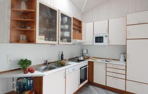 特拉弗明德Freibeuterweg 8 - Dorf 6的厨房配有白色橱柜和水槽