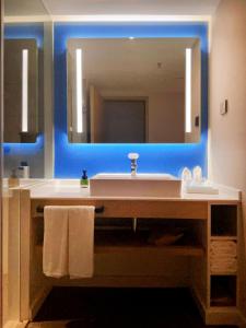 呼和浩特呼和浩特东站智选假日酒店的一间带水槽和大镜子的浴室