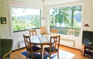 蒙克达尔Bergsvik的一间带桌椅和大窗户的用餐室