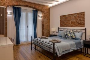 米兰Luxury Apartment in Milan Center的一间卧室设有一张床和砖墙