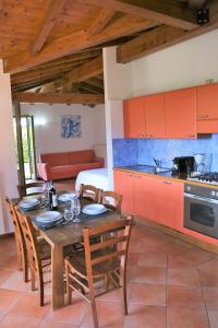 坎诺比奥Appartamenti Ferrari Residence的厨房以及带木桌和椅子的用餐室。