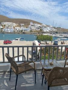 阿斯提帕莱亚镇Xenios Zeus Apartments的阳台配有桌椅,享有海港的景致。