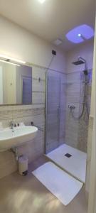 帕尔盖利亚Hotel Residence Piccolo的带淋浴、盥洗盆和镜子的浴室
