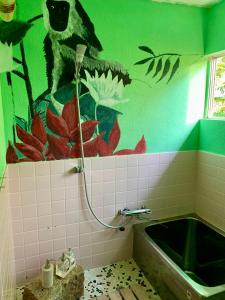 玉野市Hanatsu的带浴缸和绿色墙壁的浴室