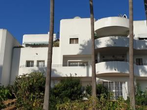 EsteponaEstepona Golf Apartment的一座白色的建筑,前面有棕榈树