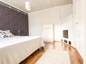 HaapavesiMaalaistalo maatilamiljöössä的卧室配有一张白色大床和地毯。