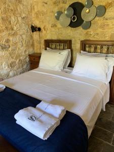 梅加尼西岛Villa Danae的卧室配有带毛巾的大型白色床