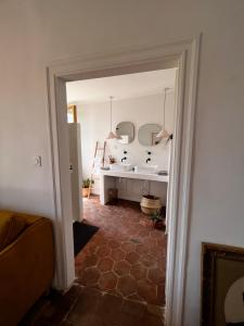 ComprégnacLes Roches的走廊设有带水槽和镜子的浴室