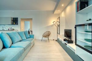米兰CaseOspitali - Casa Janas, elegante trilocale per 5 in zona centrale的客厅配有蓝色的沙发和电视
