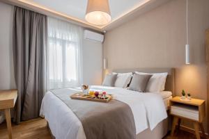 兹拉马GIARDINO High living suites的一间酒店客房,配有一张床铺,上面装有水果盘