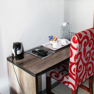 哈博罗内Platinum Hotel的一张红白椅子,坐在木桌旁