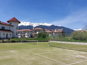 班斯科Pinerose Resort的一座以山脉为背景的网球场