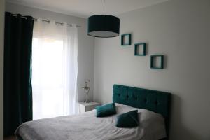 博格泽利卡Turkusowa Liwia的一间卧室配有一张带绿色床头板的床和窗户