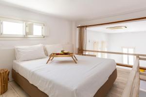 图罗斯NAMASTE Boutique Apartments Mykonos的一间卧室配有一张大床,上面有桌子
