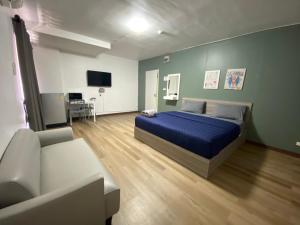 暖武里府Baansuay Rattanathibet Apartment的一间卧室配有蓝色的床和沙发