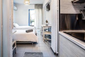 波罗斯Ninetta's Studios的酒店客房设有两张床和盥洗盆