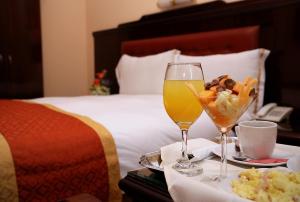 利马普林塞萨酒店的一间酒店客房,床上备有食品和饮料托盘