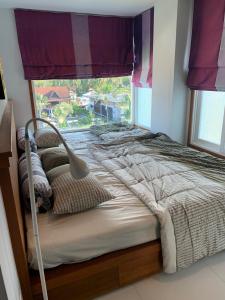 Ban Na DanKhanom Beach Residence Sea & Mountain View - 1 Bedroom的一张位于带大窗户的房间内的床铺