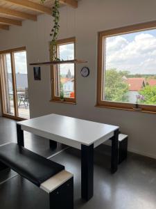 CaldenHaus am See的窗户的客房内配有一张白色桌子和长凳
