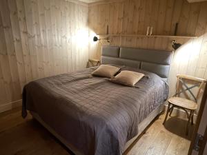 尤坎Gaustatoppen Lodge - Mountain View - Gaustablikk的一间卧室配有一张床和一把椅子