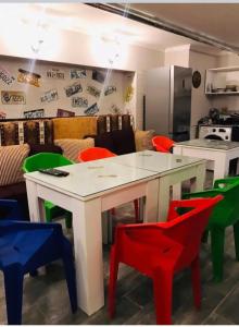 巴统Hostel VOYAGE的厨房配有白色的桌子和五颜六色的椅子