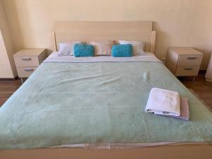阿斯塔纳Комфортабельная комната в квартире的一张大床,配有两个枕头和毛巾