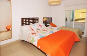 贝纳阿维斯3 Bedroom Townhouse Benahavis Village的一间卧室配有一张带橙色毯子的床