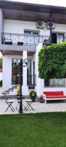 埃里温Garden Lounge Hotel的白色建筑前的红色长凳