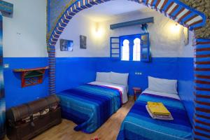 舍夫沙万拉西柏之家旅馆的蓝色墙壁客房的两张床