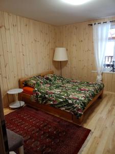 Dobrzyniewo DużeAgroturystyka Podlasie的一间卧室配有一张床、一张桌子和一个窗户。
