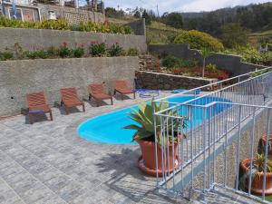 伊斯特雷托达卡耶塔Banda Do Sol Self Catering Cottages的庭院设有游泳池、椅子和植物